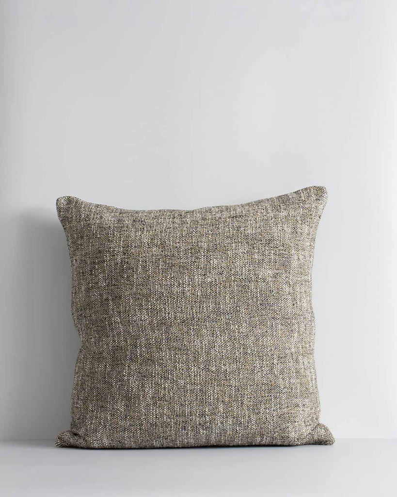A textured woven cushion in shades of pebble brown and ercu, by Baya