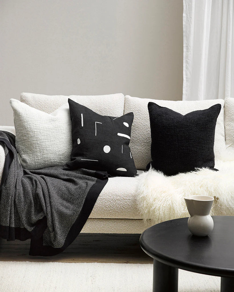 Black and white cushions on a creamy white boucle couch