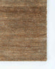 A corner image of the Fairbanks floor rug in shade Sand, a deliciously warm toned brown handwoven piece. 
