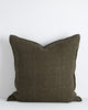 A large cushion in a soft but textural linen with a flange edge in deep green. By Baya