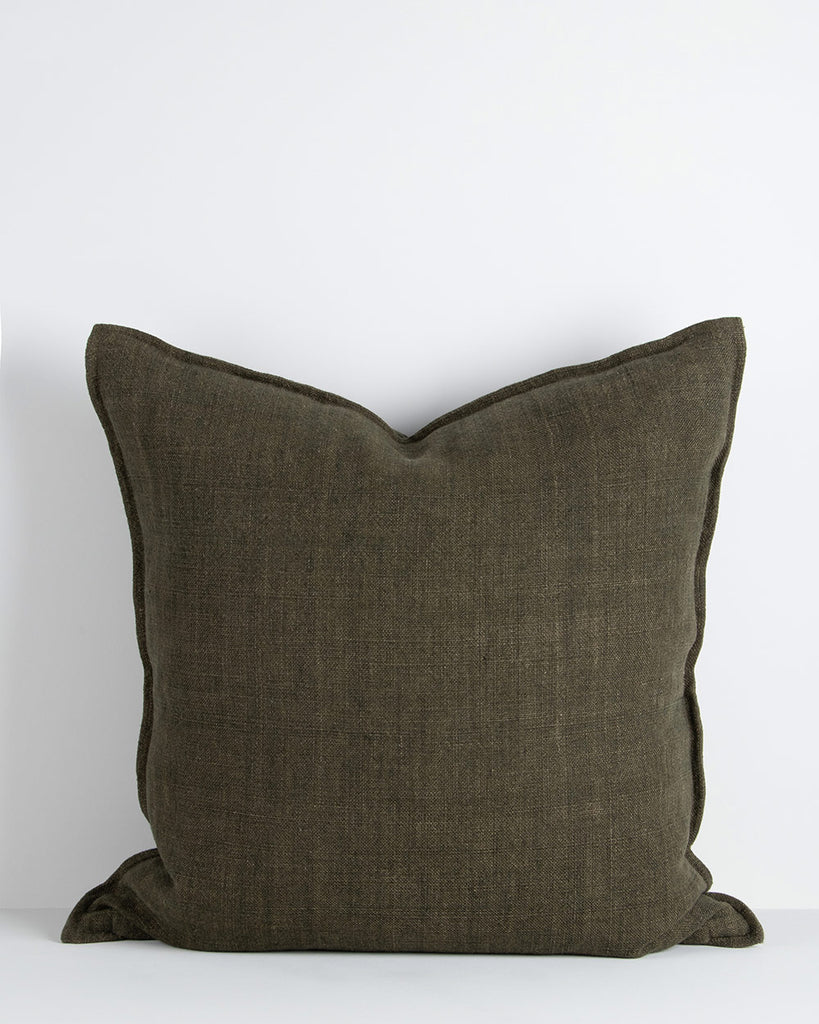 A large cushion in a soft but textural linen with a flange edge in deep green. By Baya