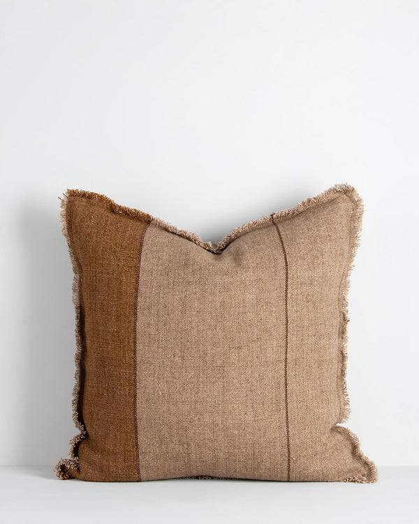 A textural linen cushion with an asymmetric pattern in shades of warm brown with fringing all the way around. By Baya
