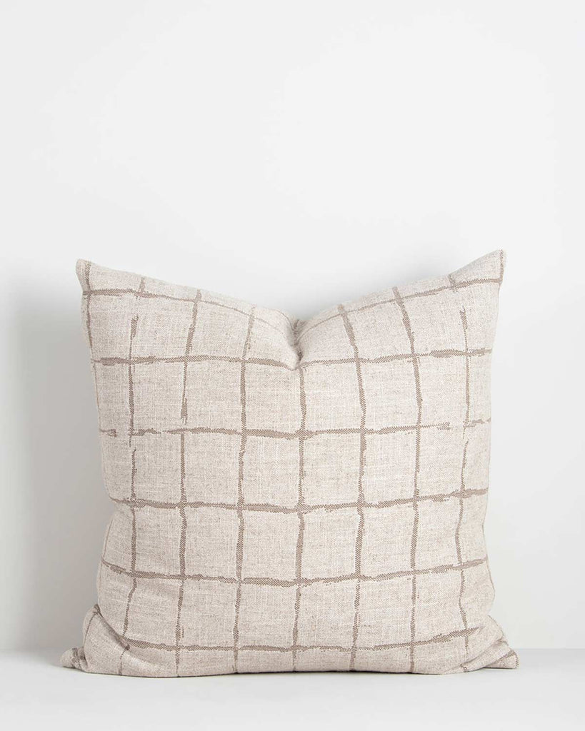 The modern patterned Harrison cushion in taupe by Baya, featuring a beige grid design in a hand-painted style on a natural linen-look base.