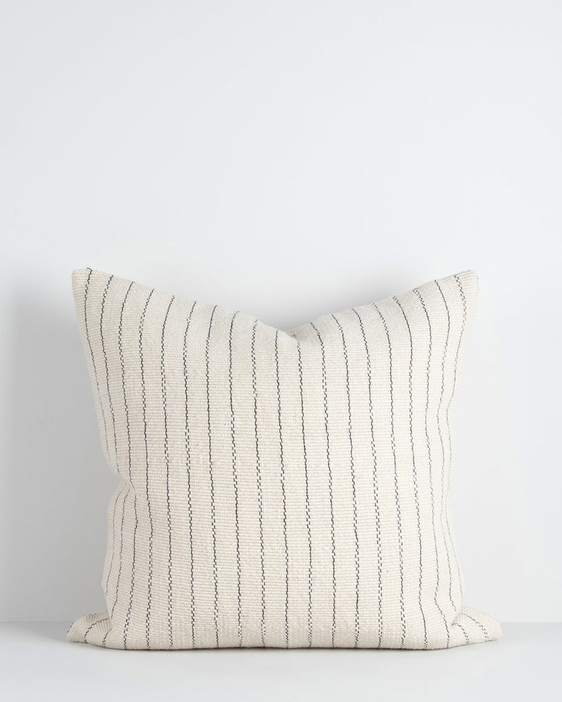 A handwoven wool cushion in shades of cream with navy vertical stripes. By Baya