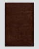 A full image of the Norfolk floor rug in the shade Chocolate. The border of the rug is cut-pile in a minimalist and refined design, and the pile of the rug's centre is luxuriously deep. 