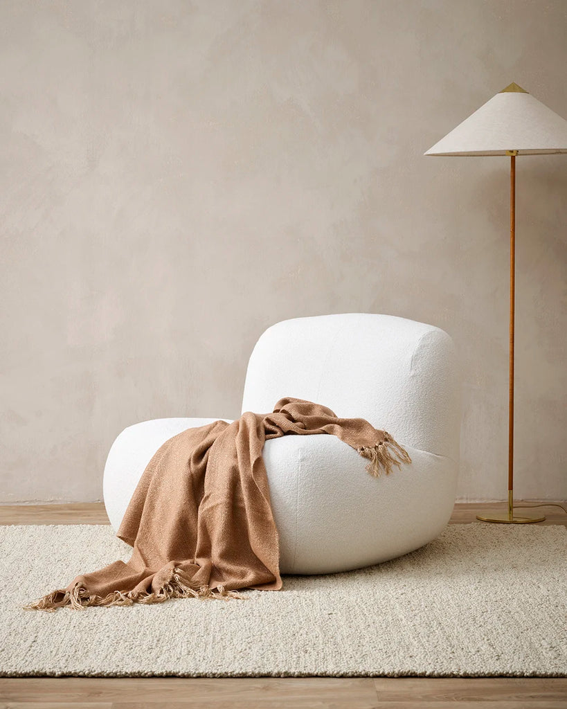 The Baya 'Richmond Sunset' throw blanket drpaed over a chair in a contemporary nz living room