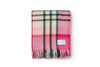 A folded pink and green check throw blanket by Ruanui Station, NZ