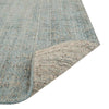 Close up of the weave of a viscose blend statement rug in shades of muted ocean blue, by Globe West and Soren Liv NZ. The edge is flipped up to show the underside of the rug. 