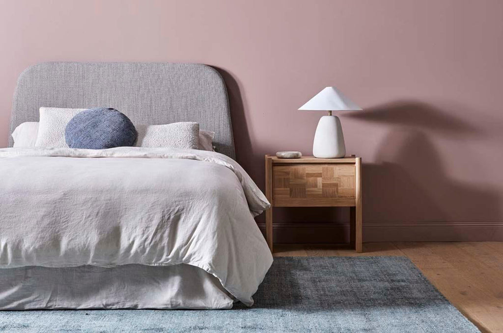 A beautiful soft viscose blend statement rug in shades of muted ocean blue, by Globe West and Soren Liv NZ, situated in a modern bedroom.