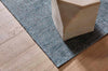 A beautiful soft viscose blend statement rug in shades of muted ocean blue, by Globe West and Soren Liv NZ, underneath a plinth. 