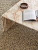 A textural wool blend boucle style rug by Globe West and Soren Liv NZ in shades of light grey and brown, situated in a stylish living room. 