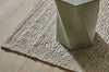 A textural wool blend boucle style rug by Globe West and Soren Liv NZ in shades of warm beige and light brown, situated under a coffee table.