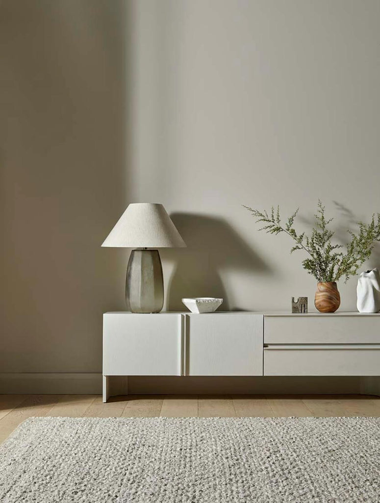 A textural wool blend boucle style rug by Globe West and Soren Liv NZ in shades of warm beige and light brown, situated in a stylish simple living room. 