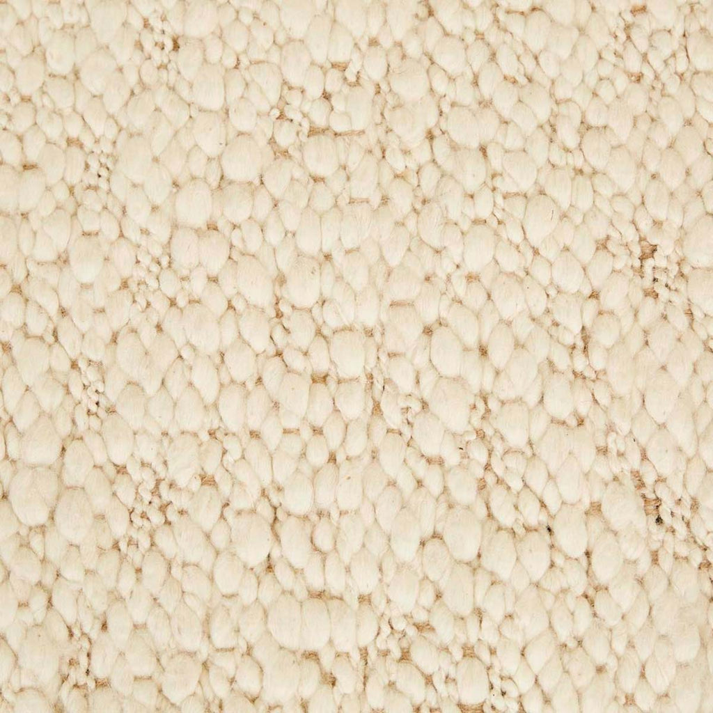 Close up of the weave of a textural wool blend boucle style rug by Globe West and Soren Liv NZ in shades of warm ivory and cream. 