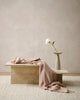 The Baya 'Cromwell Blush' throw blanket draped on a table in a contemporary living room