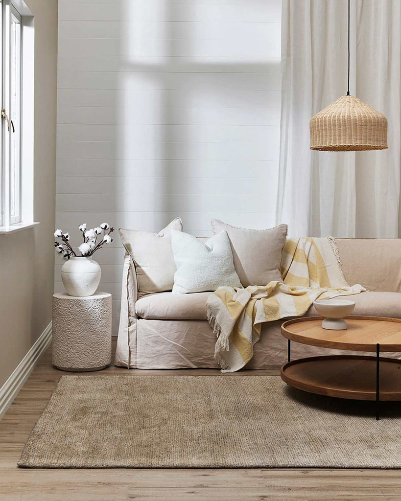 Brown floor rug and cushions by Baya NZ situated in a stylish, modern living room.