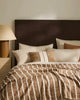 Brown and cream cushions by Weave Home nz, on a bed in a contemporary bedroom