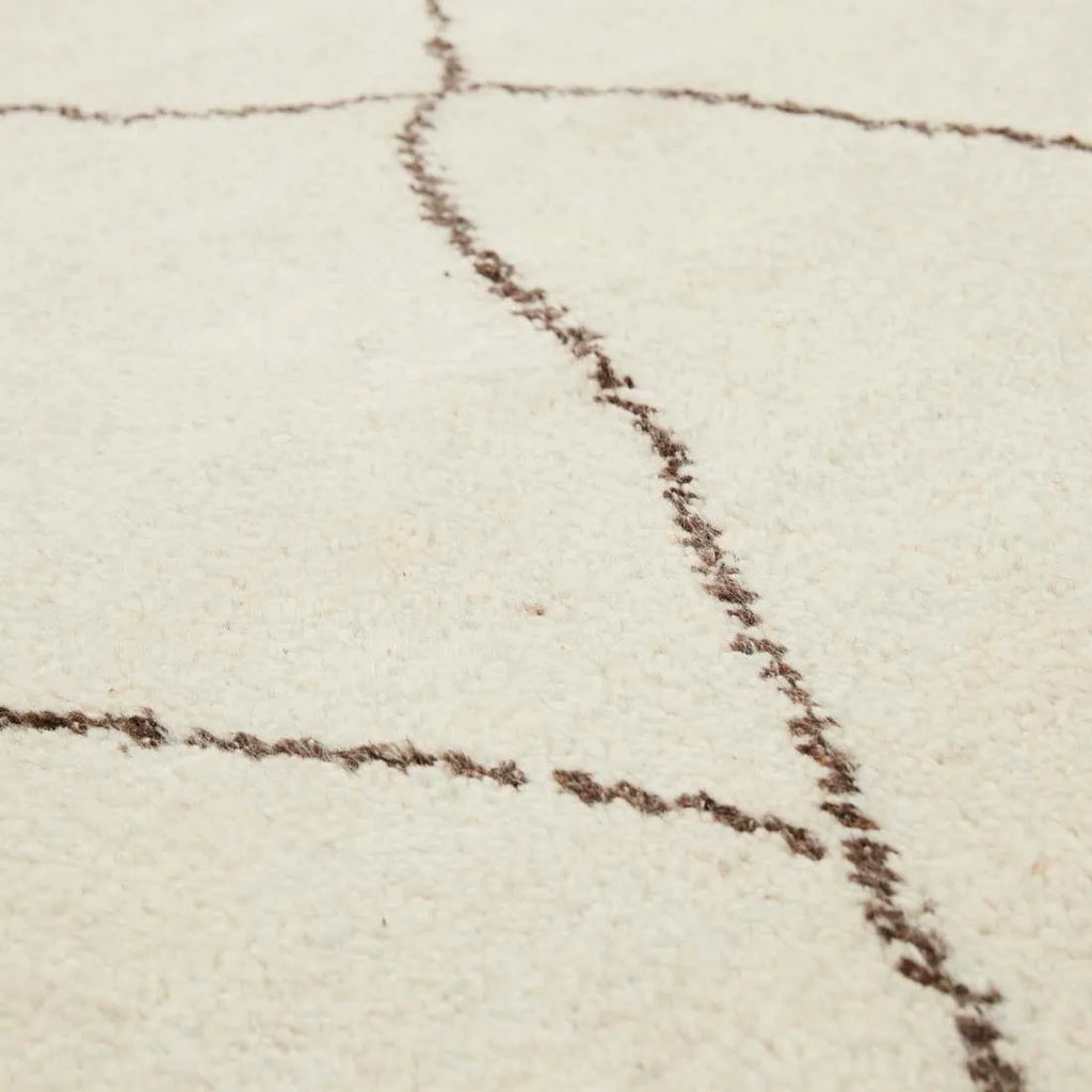 Close up of the plush pile of the wool Bower Linear rug with brown diamond detail