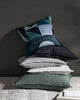 Stack of Weave Home NZ cushions against a wall in a styled room interior